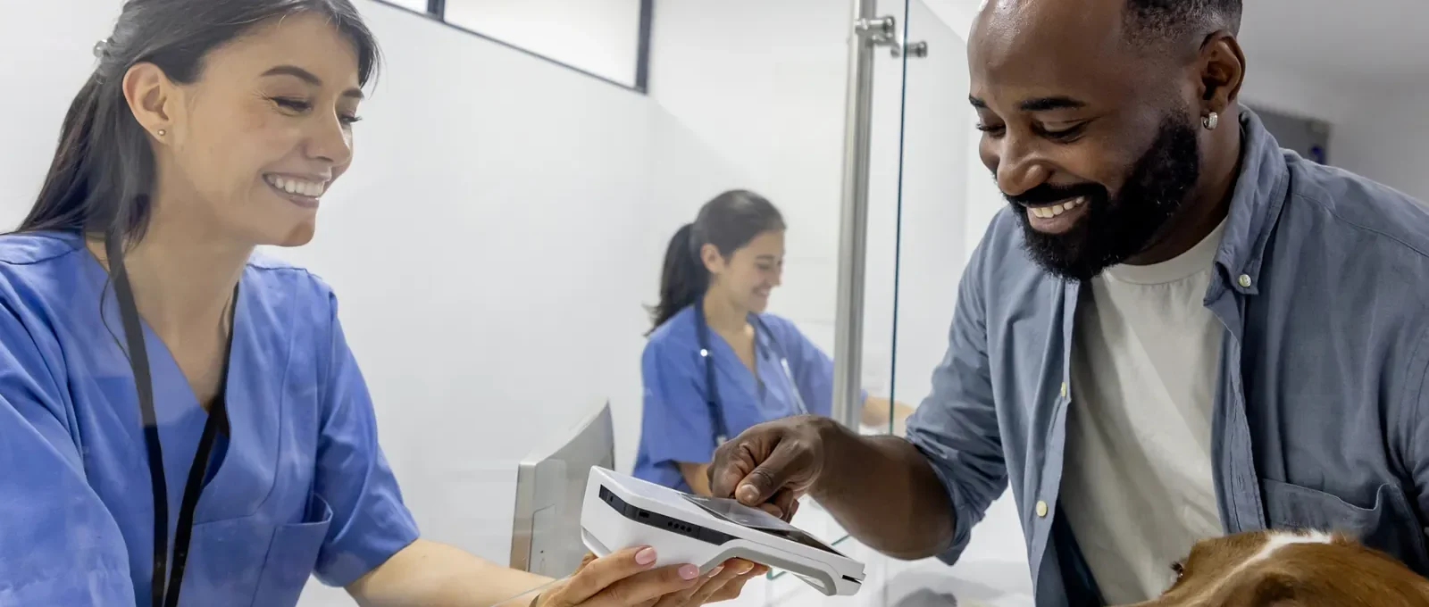 Owner with a dog at a veterinary clinic — the real cost of owning a dog reaches $22,000 to $60,000 over a lifetime