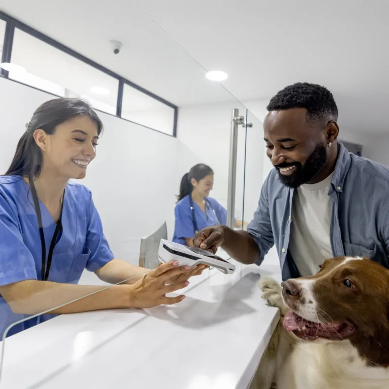 Owner with a dog at a veterinary clinic — the real cost of owning a dog reaches $22,000 to $60,000 over a lifetime