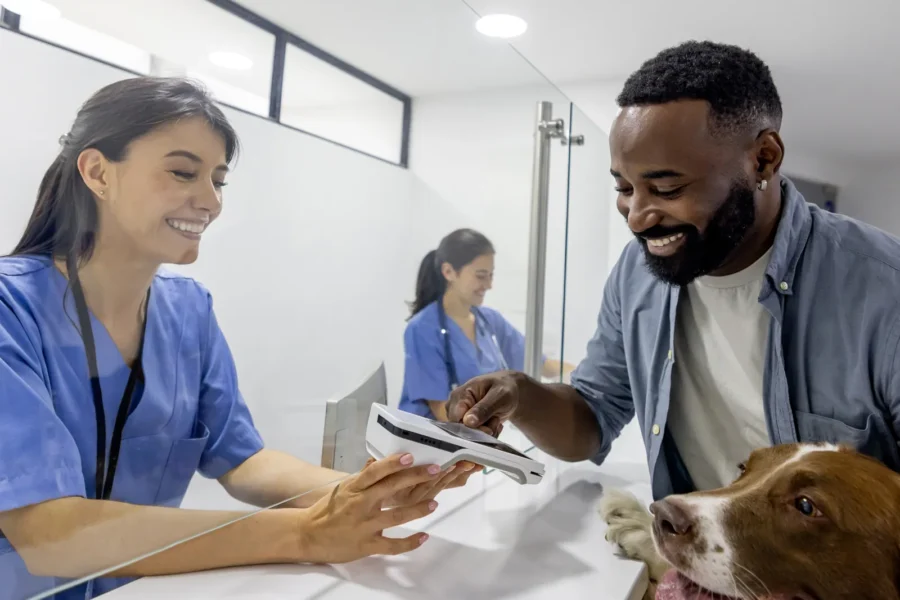 Owner with a dog at a veterinary clinic — the real cost of owning a dog reaches $22,000 to $60,000 over a lifetime