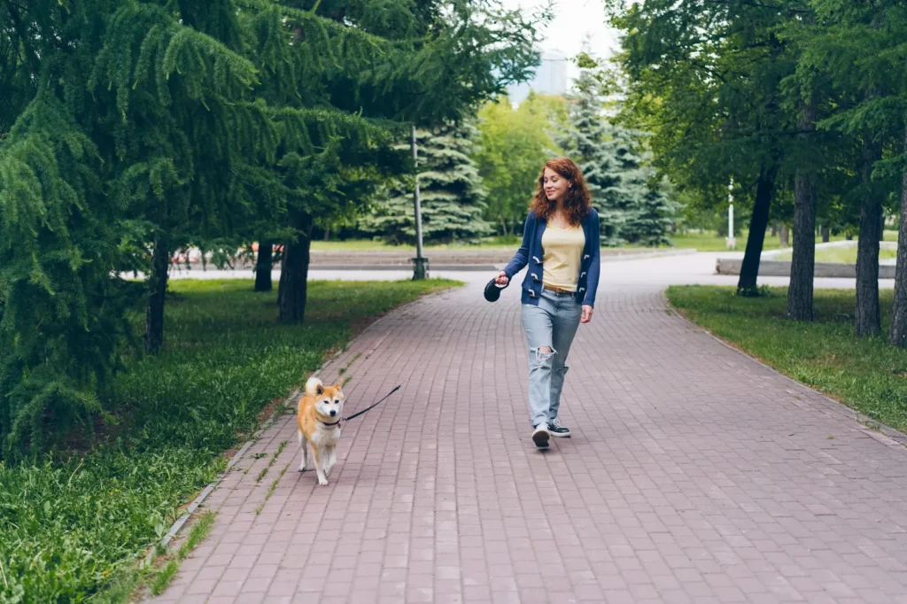Best Dog Breeds for Single Women in 2026: Top Picks for Safety, Companionship & Every Lifestyle 14 Woman walking her dog — exercise and safety together